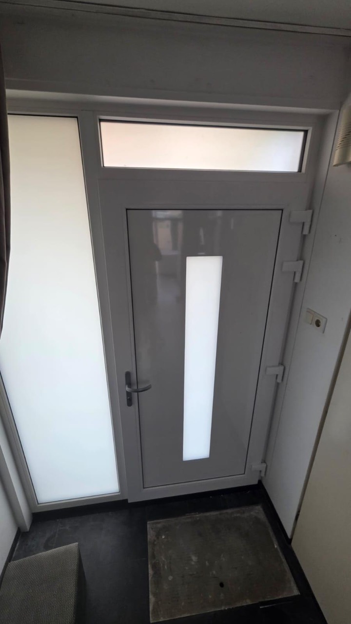 De binnenzijde van een voordeur met zijlicht en bovenlicht.