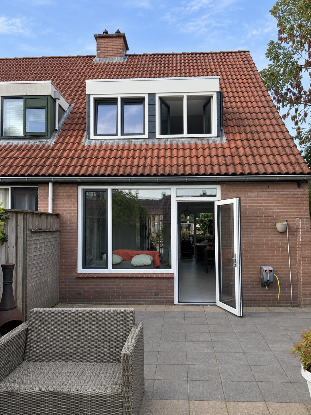 Presentatiebeeld van de geplaatste kozijnen en achterdeur. Montagefoto geretoucheerd; personen en losse bouwmaterialen zijn weggewerkt.